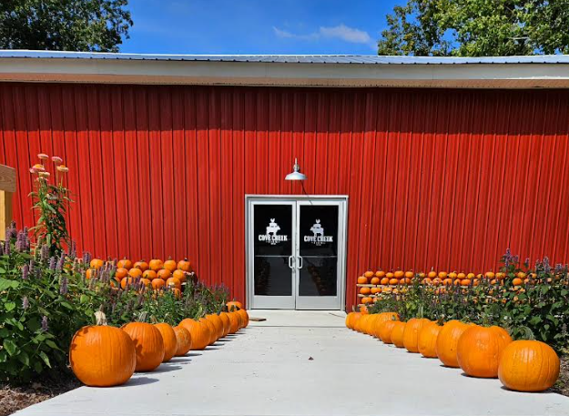 The red play barn lined with pumpkins and mums
