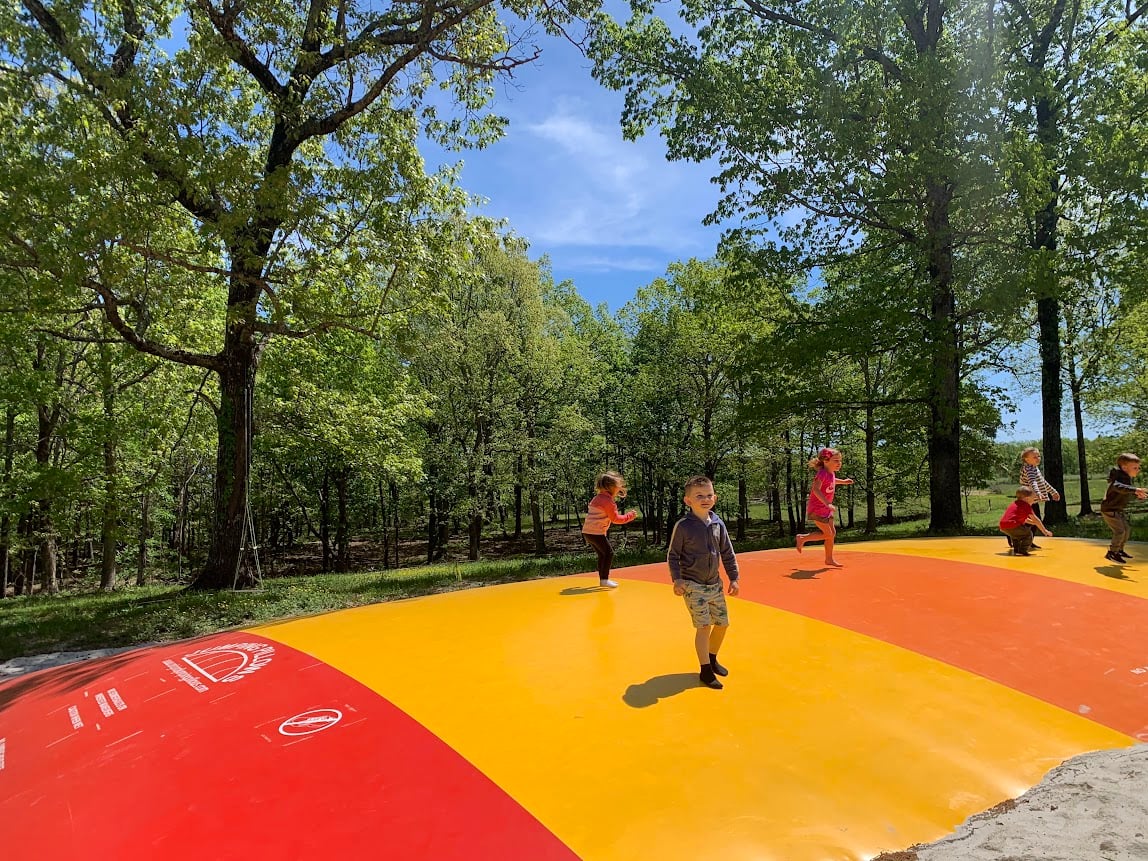 Kids bouncing on the yellow and red jump pillow